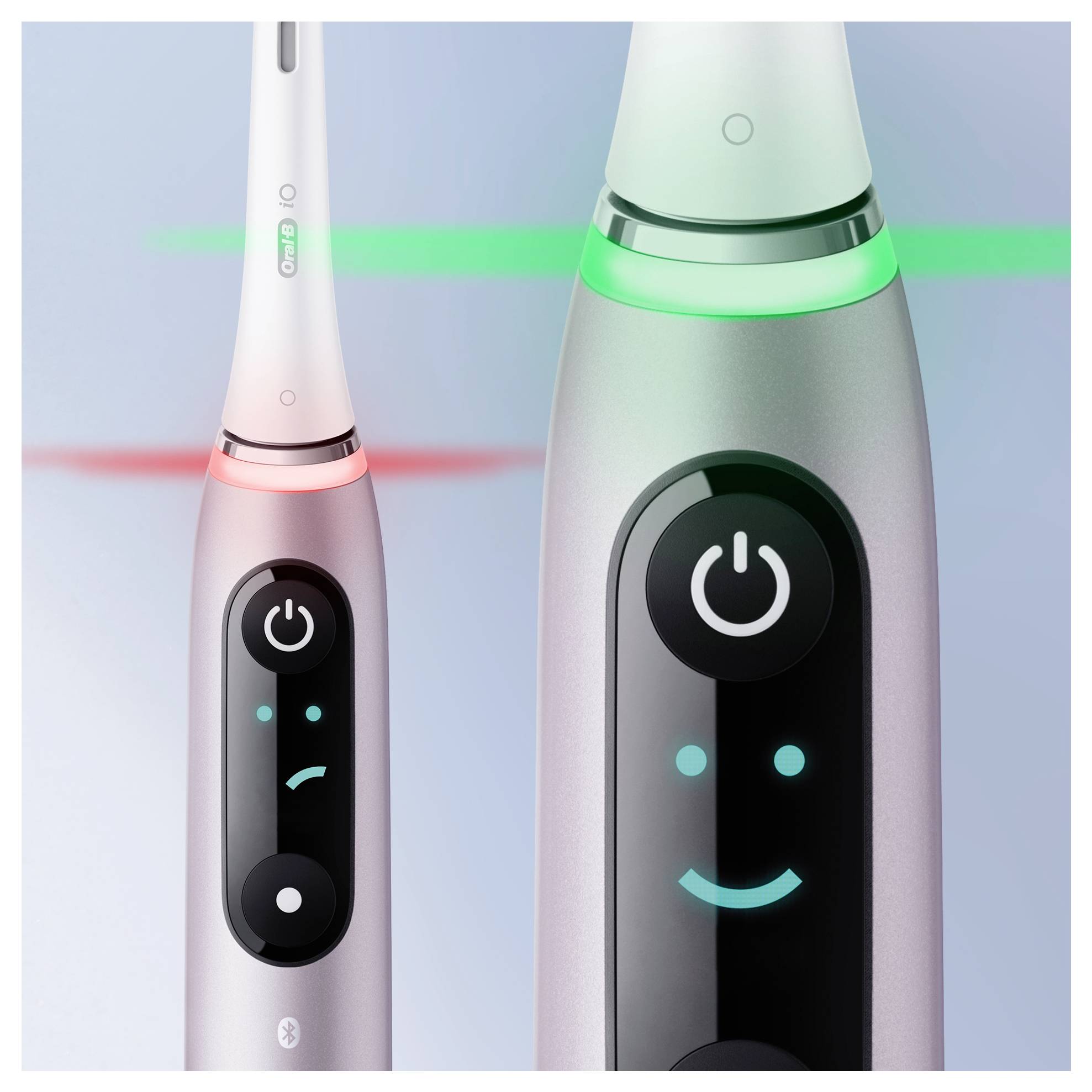 Zwei elektrische Zahnbürsten: eine mit einem traurigen Gesicht und rotem Licht, was auf ein Problem hinweist, und eine andere mit einem fröhlichen Gesicht und grünem Licht, was auf einen guten Zustand hindeutet.