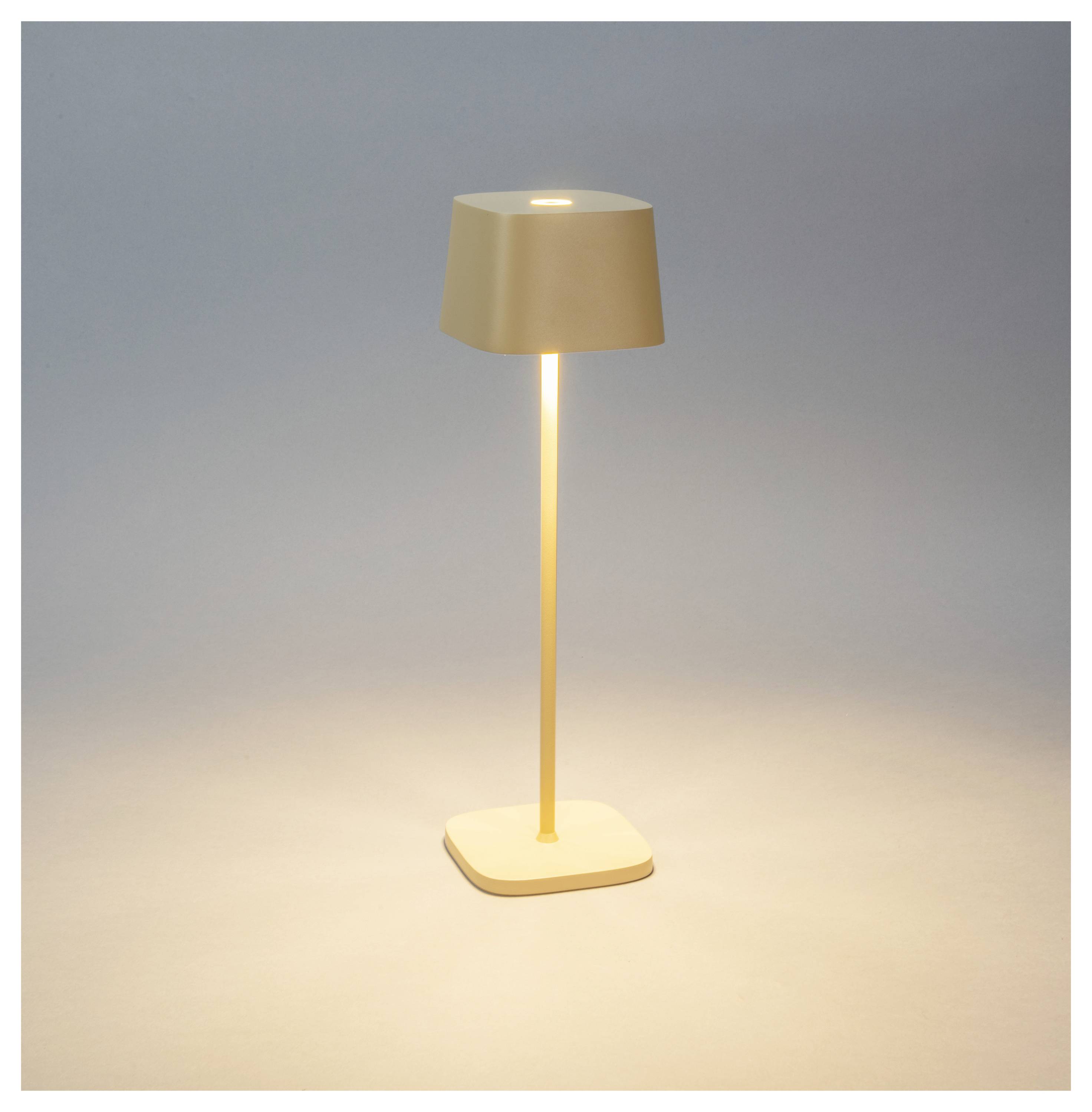 Eine moderne Stehlampe mit einem quadratischen Lampenschirm und Fuß, die weiches Licht ausstrahlt, steht auf einer glatten Oberfläche vor einem neutralen Hintergrund.