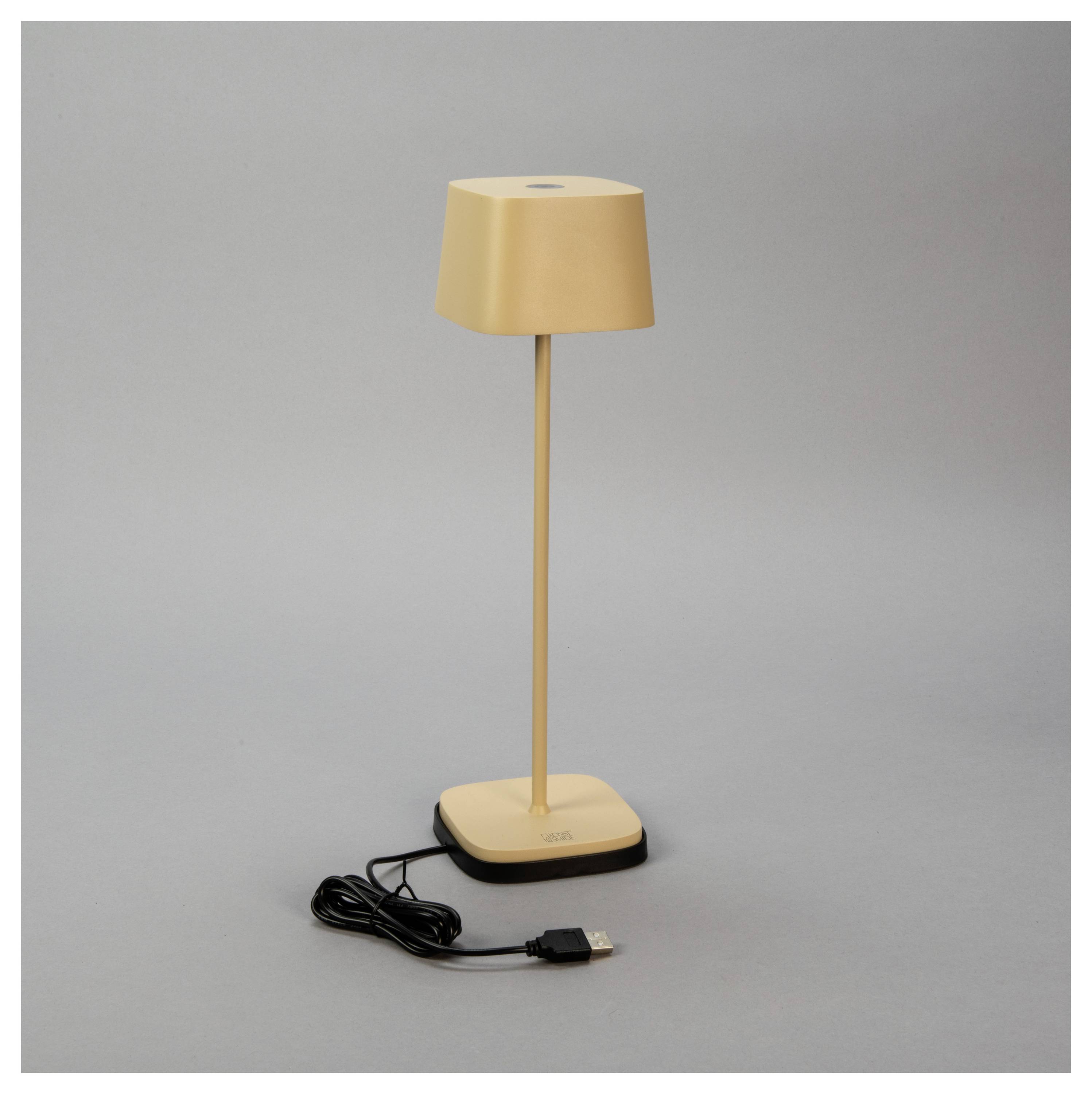 Eine schlichte, moderne Schreibtischlampe in Gold mit quadratischer Basis und USB-Netzkabel vor grauem Hintergrund.