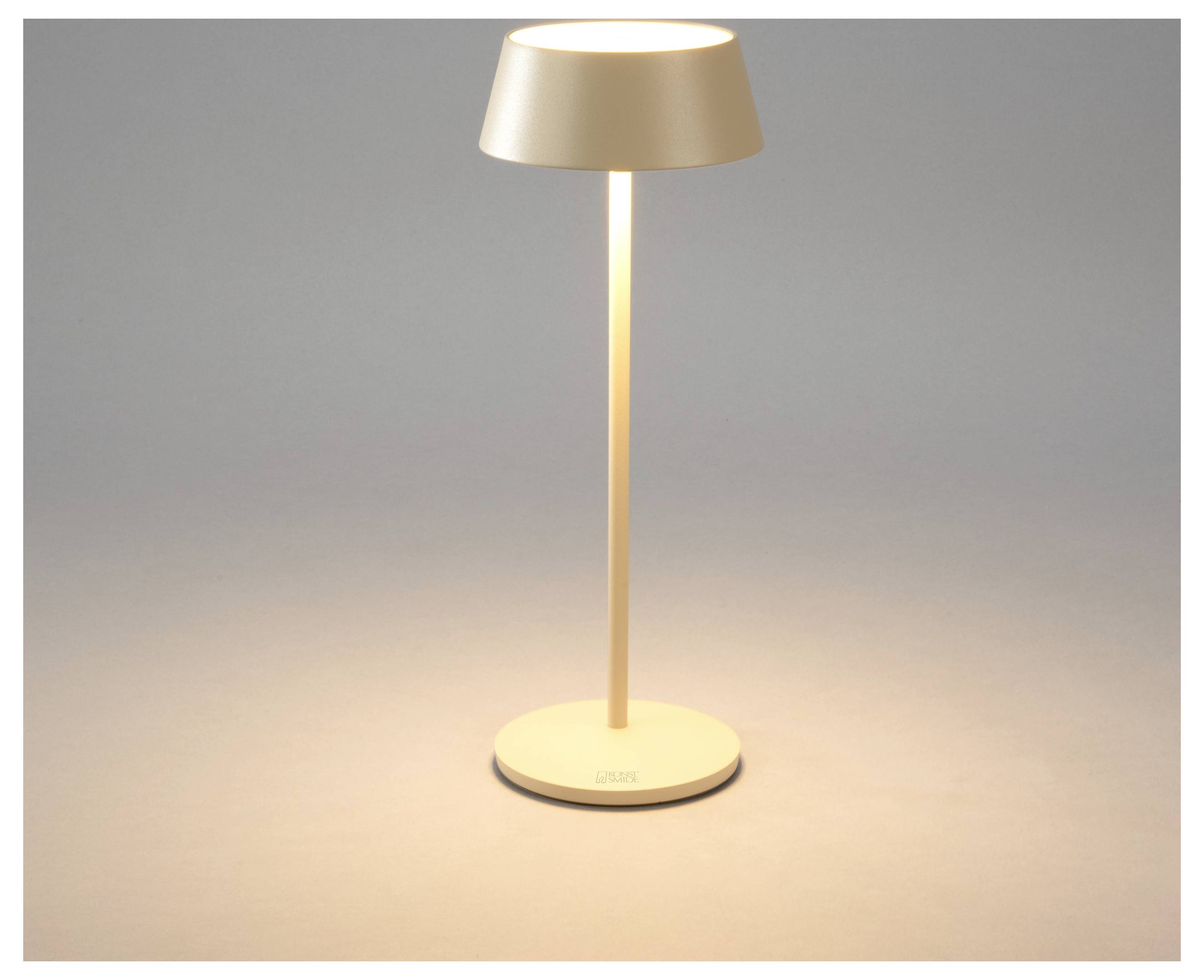 Eine moderne Tischlampe mit einem dünnen Ständer und einem breiten, flachen Schirm verbreitet ein warmes Leuchten auf einer neutralen Oberfläche.