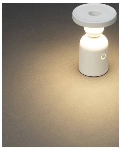 Eine weiße, moderne Tischlampe, die sanft auf einer dunklen Oberfläche leuchtet und einen sanften Lichtkreis um sich herum wirft.