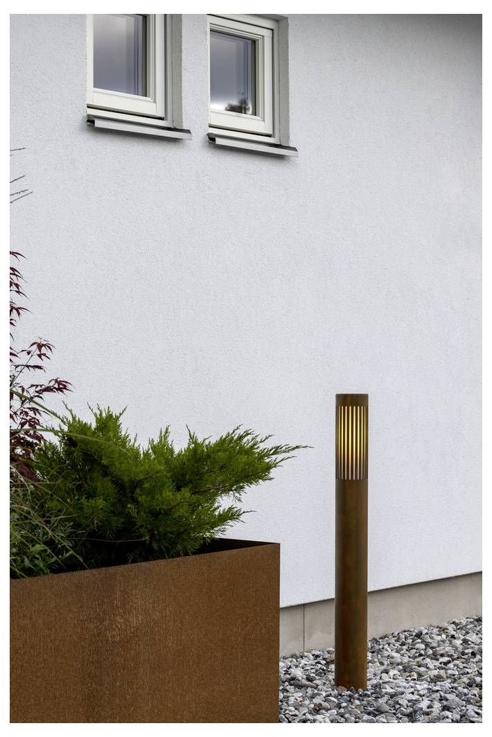 Eine moderne Außenleuchte neben einer strukturierten weißen Wand, mit einer grünen Topfpflanze darunter und Kies, der den Boden bedeckt.