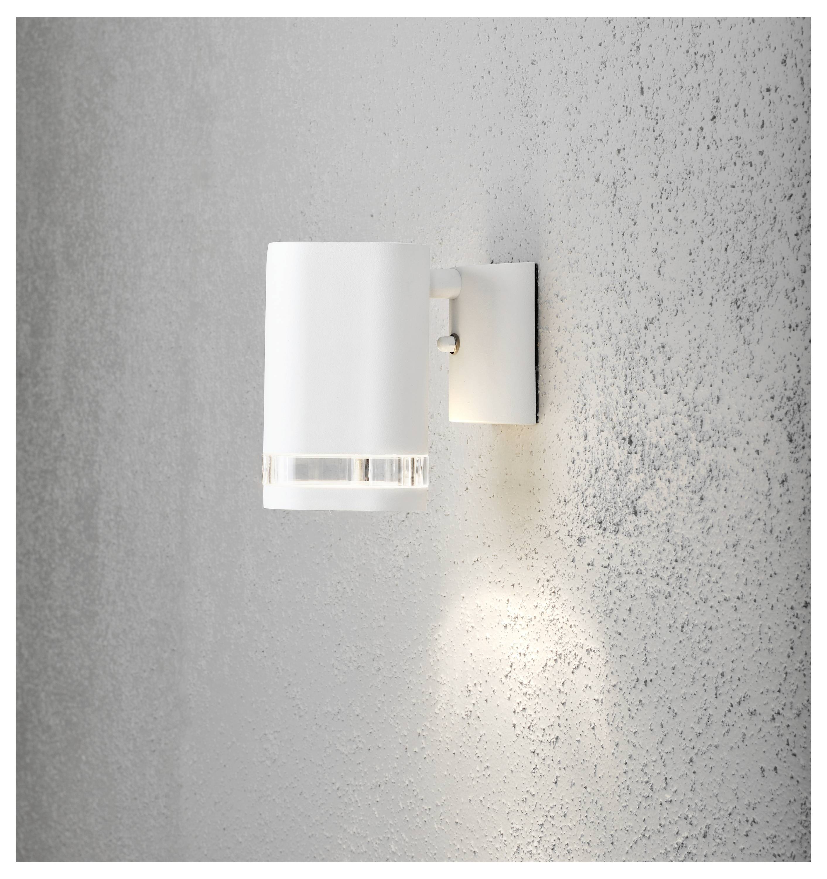 Eine moderne weiße Wandleuchte strahlt ein sanftes Licht gegen eine strukturierte graue Wand und erzeugt eine minimalistische und zeitgemäße Atmosphäre.