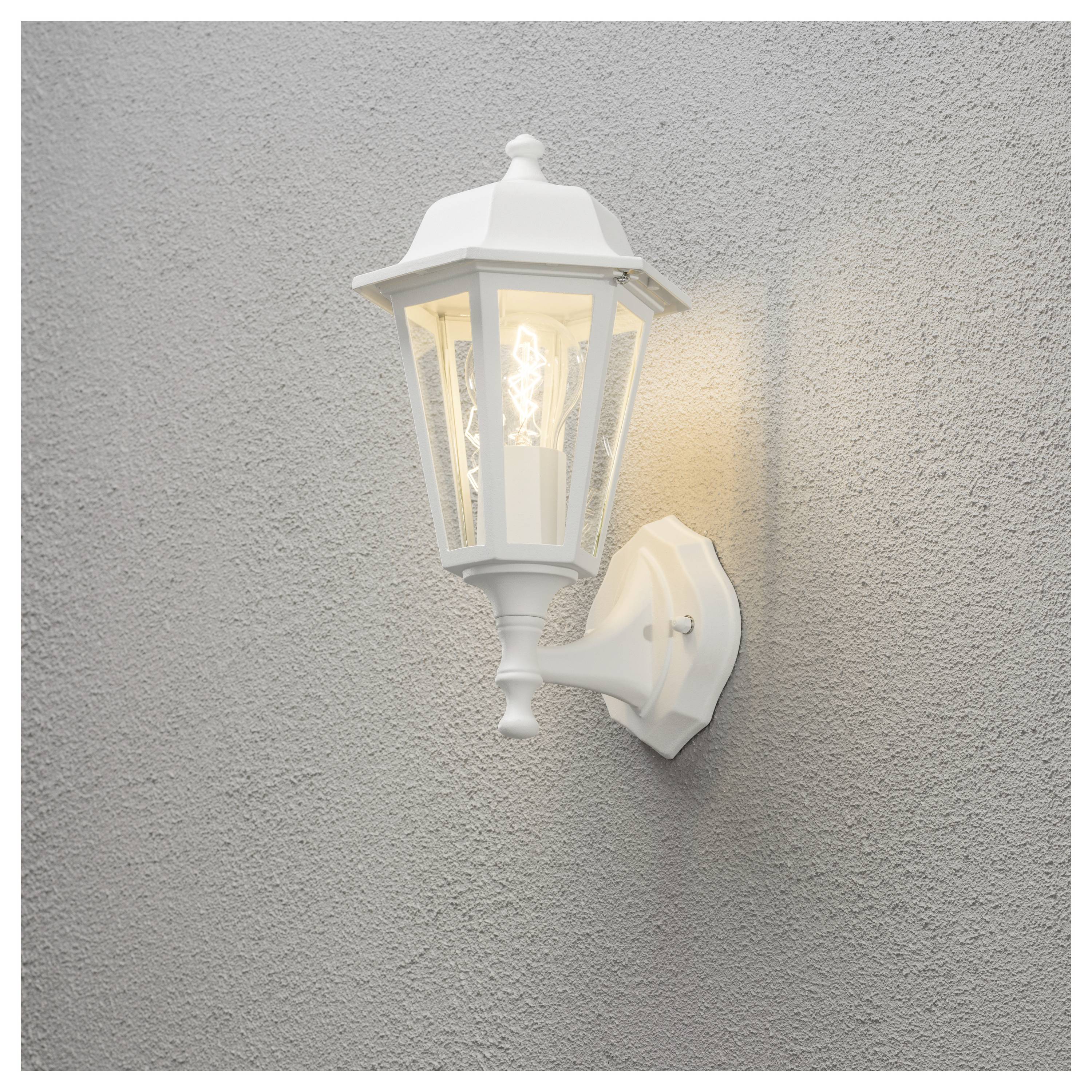 Eine weiße Außenwandlaterne strahlt Licht aus, installiert an einer grauen strukturierten Wand und sorgt für Beleuchtung sowie dekorativen Stil.