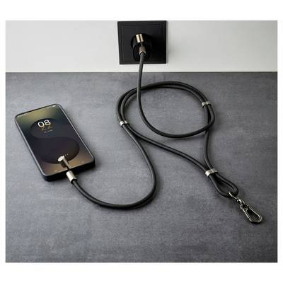 Ein Smartphone, das '8:22' anzeigt, lädt auf einer grauen Oberfläche mit einem schwarzen Kabel, das an eine Steckdose angeschlossen ist.