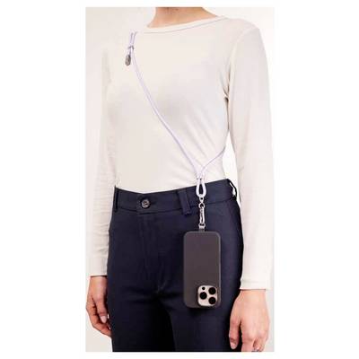 Eine Person mit einem weißen Langarmshirt und schwarzer Hose trägt ein Smartphone an einem Gurt über den Körper gehängt, was eine handfreie Möglichkeit des Telefontragens hervorhebt.