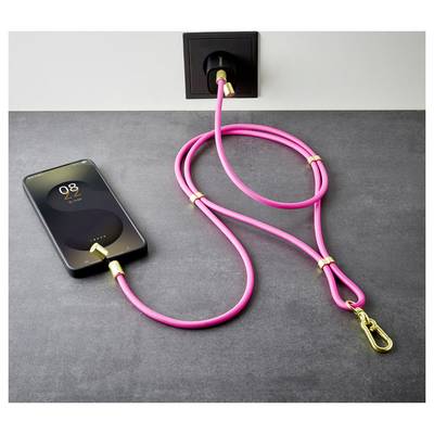 Ein Smartphone lädt auf einem Tisch mit einem rosa Ladekabel, das in eine Wandsteckdose eingesteckt ist.
