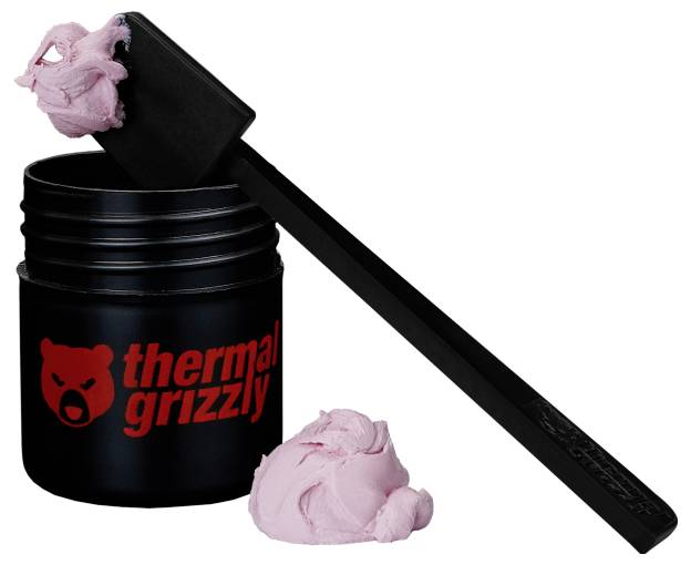 Ein schwarzer Behälter mit pinker Wärmeleitpaste, beschriftet mit 'Thermal Grizzly', mit einem Applikator, der Paste sowohl auf dem Werkzeug als auch auf dem Tisch zeigt.