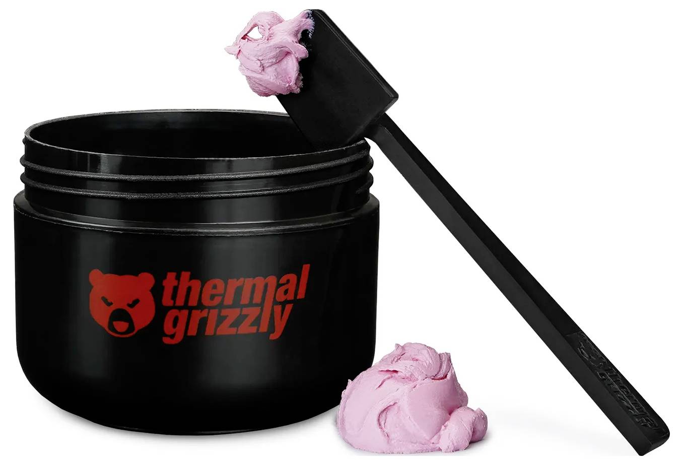Ein schwarzer Behälter mit der Aufschrift "Thermal Grizzly" mit rosa Wärmeleitpaste und einem Applikator-Werkzeug, an dessen Ende Paste zu sehen ist.