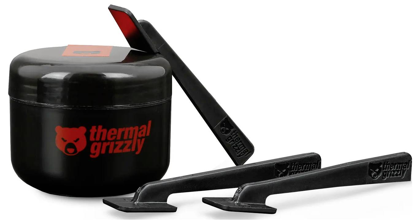 Bild eines schwarzen Behälters mit der Aufschrift Thermal Grizzly und einem roten Logo, zusammen mit drei Anwendungswerkzeugen für Wärmeleitpaste.
