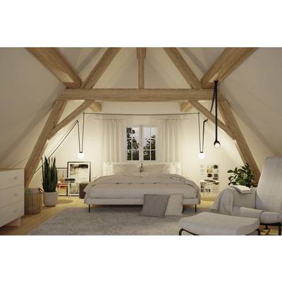 Ein gemütliches Dachgeschosszimmer mit sichtbaren Holzbalken, einem ordentlich bezogenen Bett, Nachttischen, hängenden Lampen, Pflanzen und einem weichen Sessel.