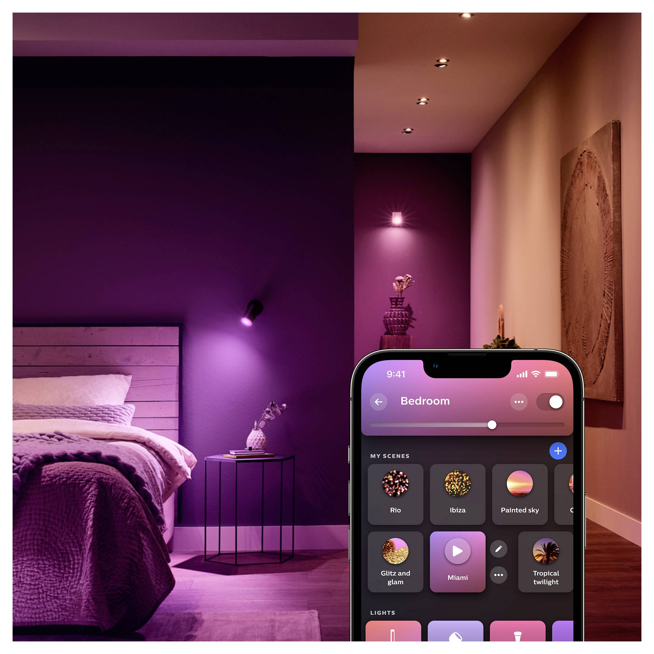 Ein modernes Schlafzimmer in violetten und rosa Tönen, mit intelligenten Beleuchtungssteuerungen auf einem Smartphone-Bildschirm, der verschiedene Szenen zeigt.
