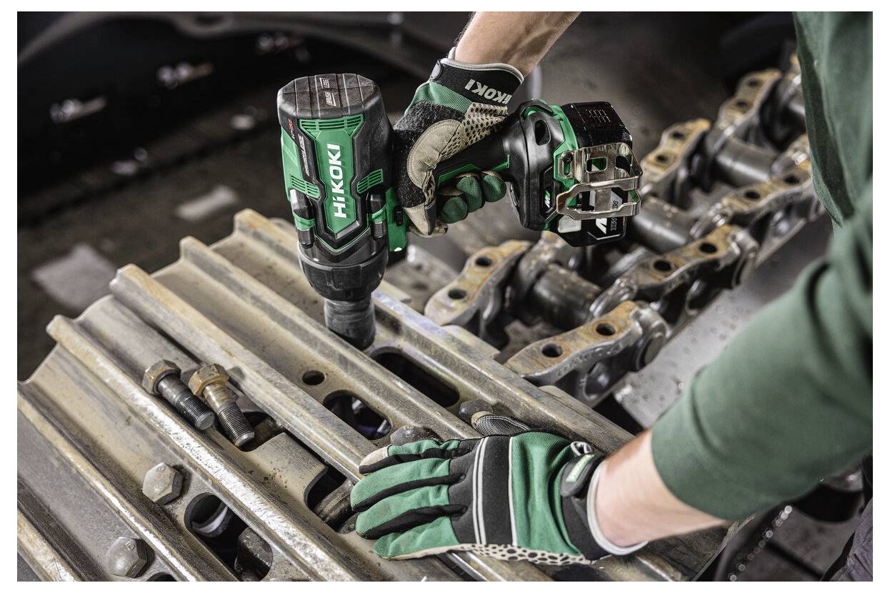 Eine Person mit Handschuhen verwendet ein HiKOKI-Elektrowerkzeug, um einen Bolzen an einer Metallkonstruktion zu befestigen.