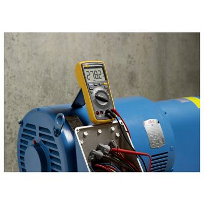 Ein digitales Multimeter zeigt '278,2' an, verbunden mit einem blauen Industriemotor, der die elektrische Spannung misst.