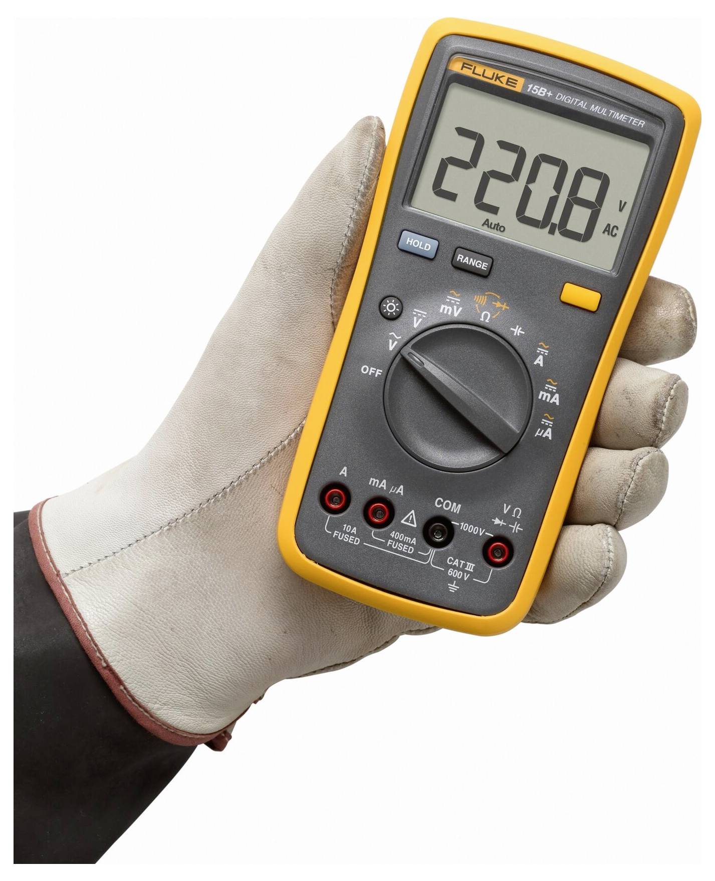 Eine Handschuh tragende Hand hält ein digitales Multimeter, das "220,8 V AC" anzeigt. Das Gerät verfügt über einen Drehschalter für verschiedene Einstellungen und verschiedene Tasten.