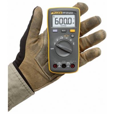 Eine Handschuh tragende Hand hält ein digitales Multimeter, das auf dem Bildschirm '6000' anzeigt und darauf hinweist, dass es zur Messung von Wechselspannung eingestellt ist.