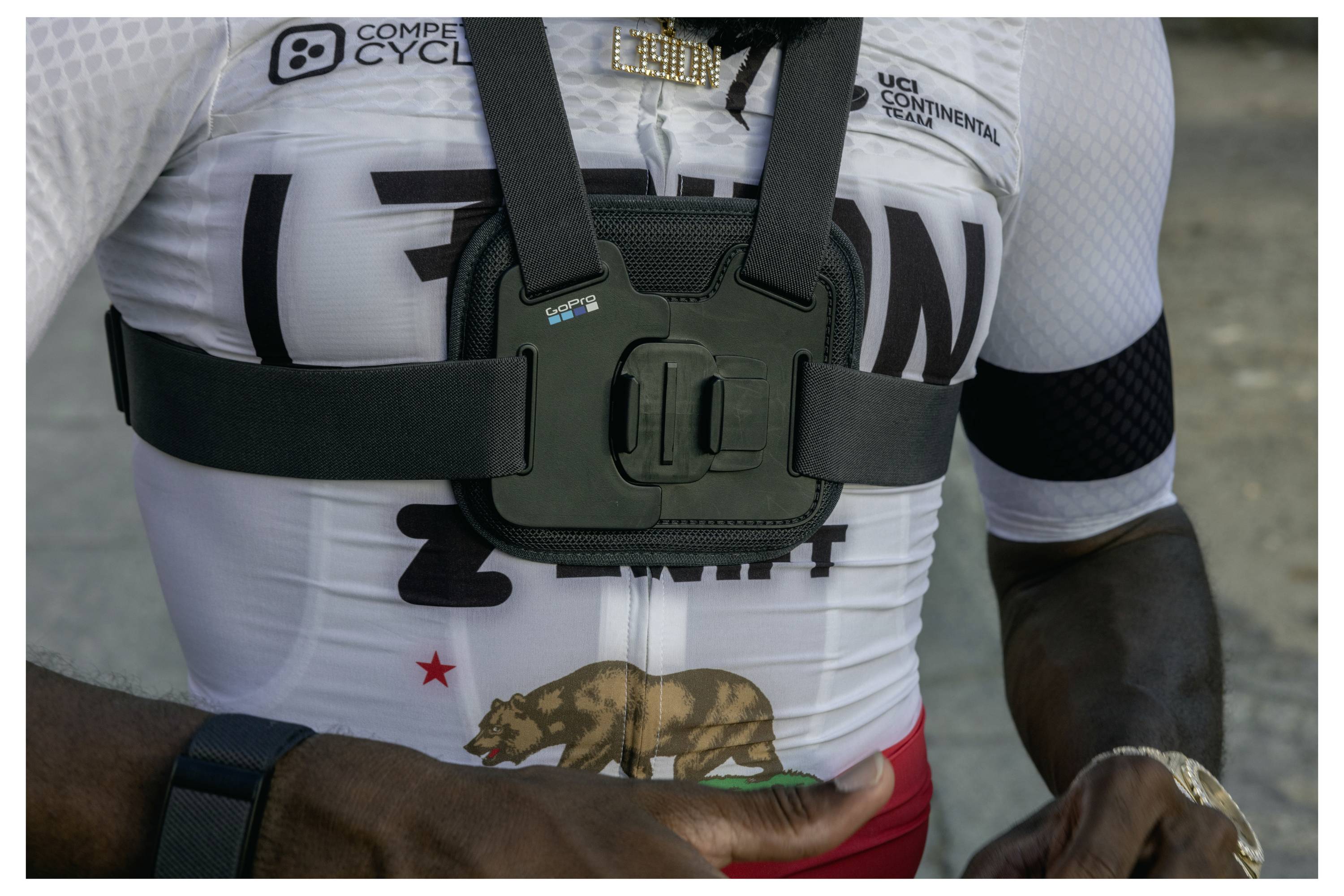 Ein Radfahrer trägt ein weißes Trikot mit der Aufschrift "California Republic" und einem Bären, ausgestattet mit einem GoPro-Kamera-Geschirr.