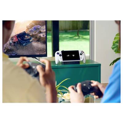 Zwei Personen spielen Videospiele auf einer Konsole mit Controllern; ein Fernseher zeigt ein Rennspiel, und ein tragbares Gerät liegt in der Nähe.