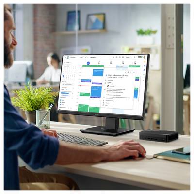 Eine Person, die an einem Schreibtisch arbeitet, mit einem Computermonitor, der einen digitalen Kalender und E-Mails anzeigt und eine konzentrierte Arbeitsumgebung andeutet.