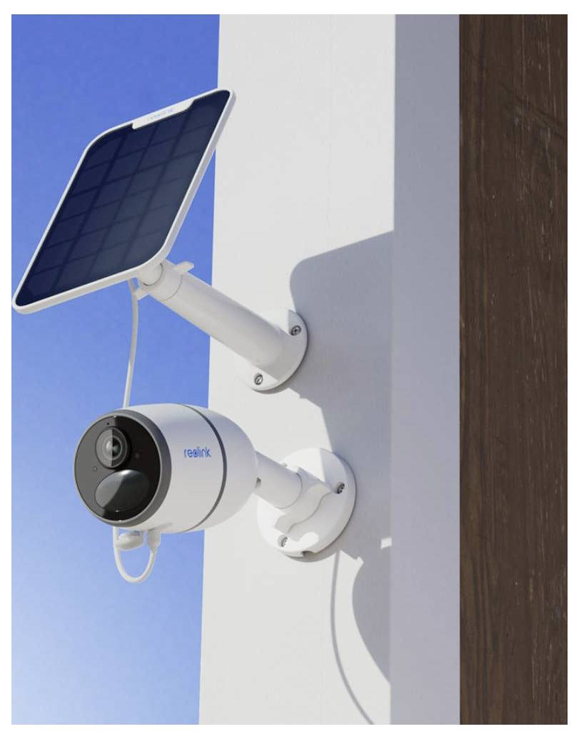 Eine solarbetriebene Sicherheitskamera, die an einer Außenwand unter einem klaren blauen Himmel montiert ist.