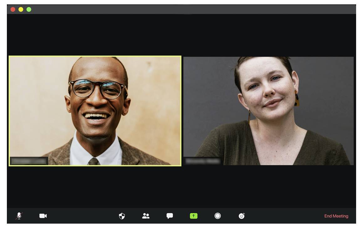 Eine Videokonferenz-Oberfläche, die zwei lächelnde Personen zeigt, die jeweils in ihrem eigenen Fenster zu sehen sind. Der linke Teilnehmer trägt eine Brille und einen Anzug, der rechte Teilnehmer ist in einem Pullover gekleidet.