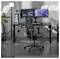 Eine moderne Gaming-Einrichtung mit einem schwarzen ergonomischen Stuhl, Dual-Monitoren mit Video- und Gaming-Inhalten, einem Gaming-PC und Ambientebeleuchtung.