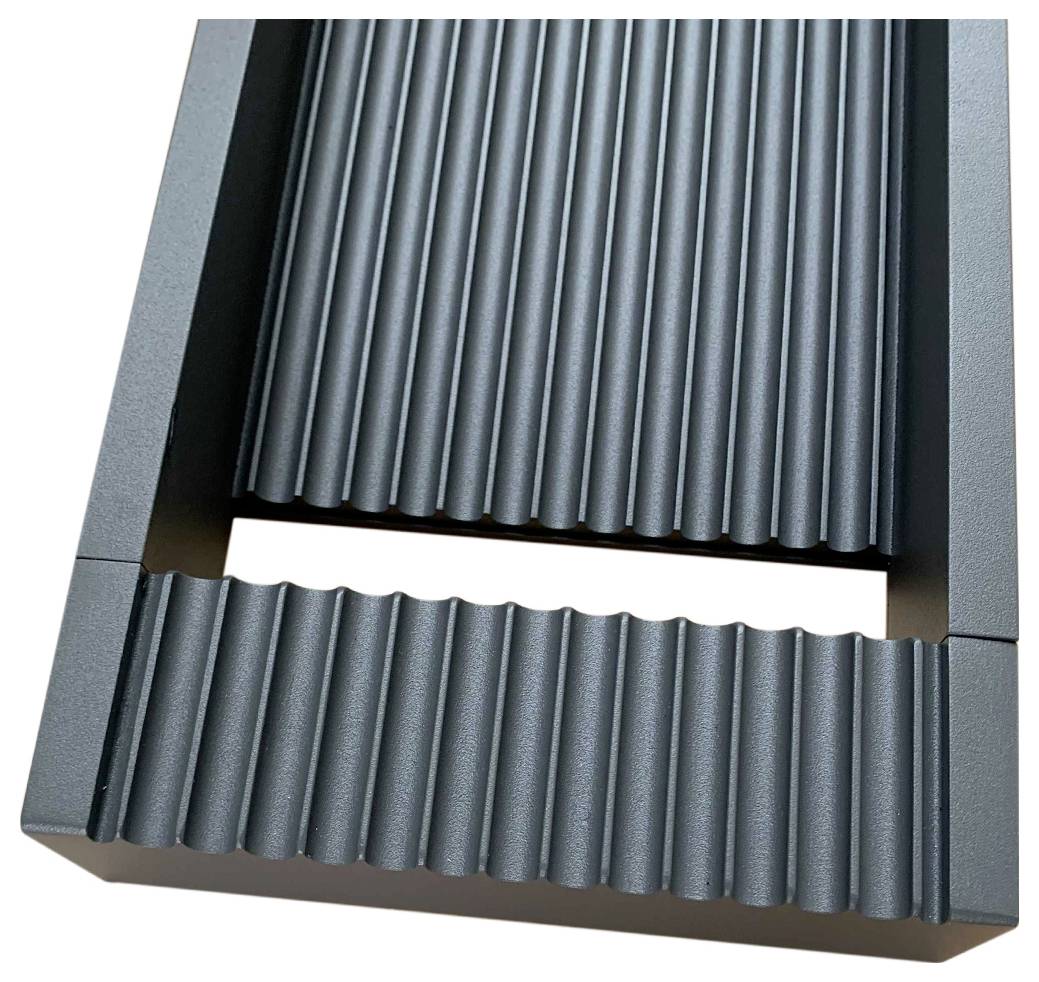 Eine Nahaufnahme einer strukturierten, gerippten Oberfläche auf einem rechteckigen Objekt, wahrscheinlich aus Metall oder Kunststoff, mit linearen Rillen.