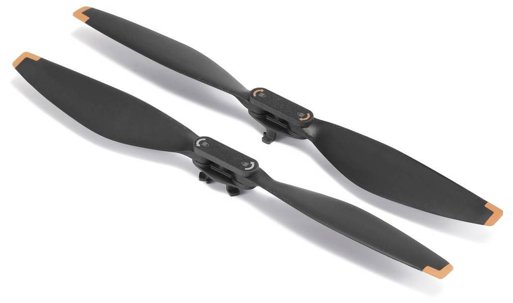 Zwei schwarze Drohnen-Propeller mit orangen Spitzen auf einem weißen Hintergrund, parallel zueinander ausgerichtet.