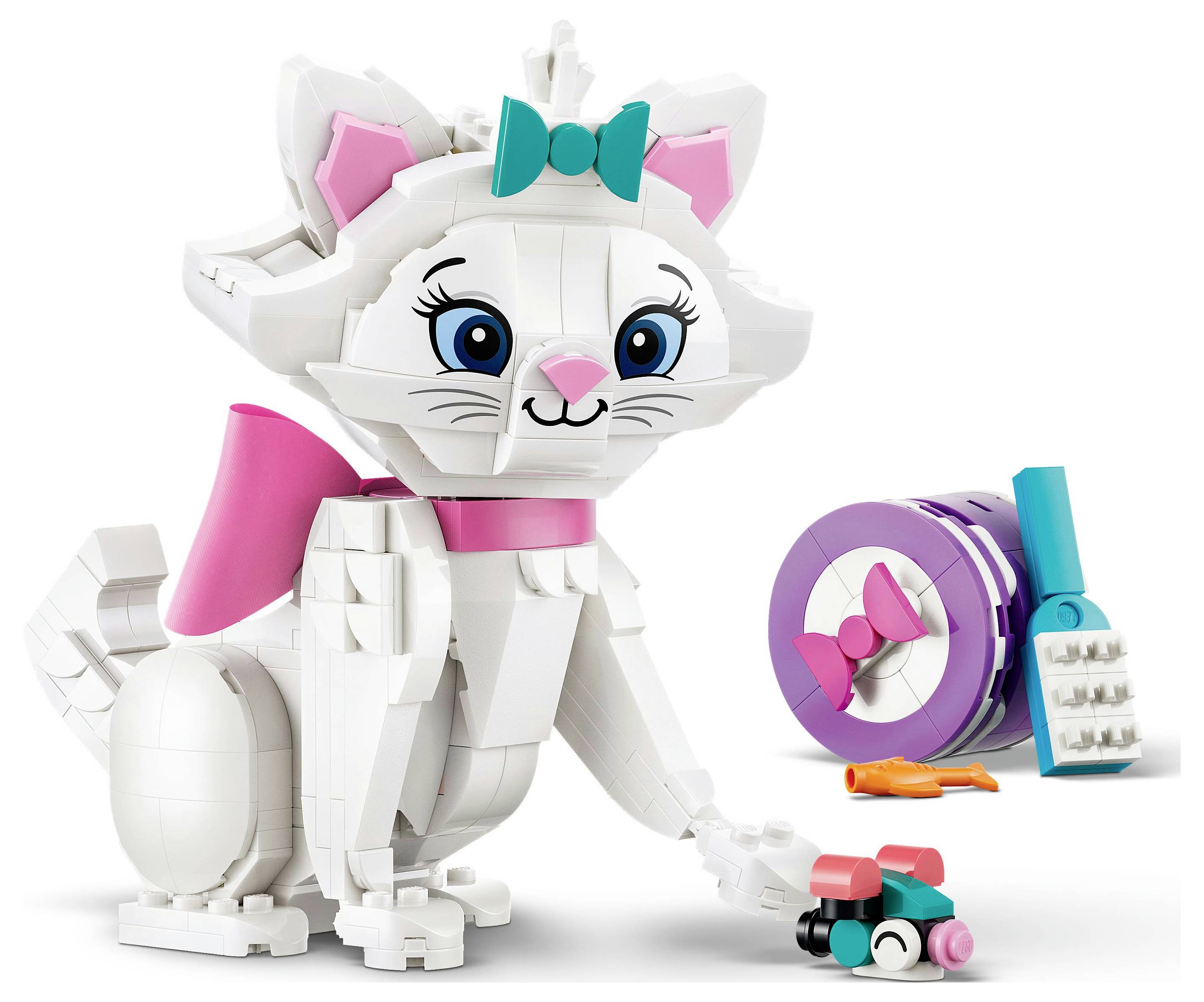 Ein LEGO-Katzenmodell mit einer rosa Schleife und Schwanz, das ein kleines baubares Spielzeug hält. Daneben liegen ein lila Katzenfutter-Artikel und eine Bürste.
