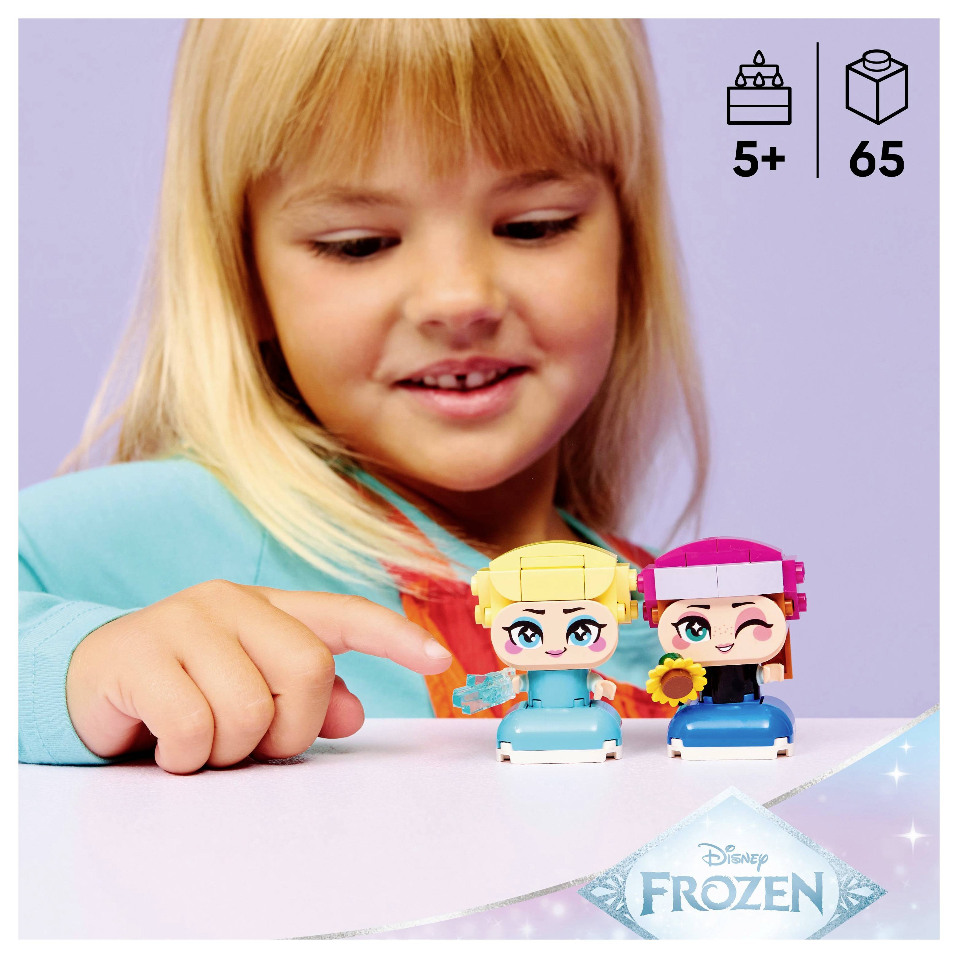 Ein Kind spielt mit zwei klotzig wirkenden Spielfiguren, die beide farbenfrohe Merkmale aufweisen. Das Bild enthält Symbole: Alter 5+ und 65 Teile, mit einem 'Frozen' Logo.