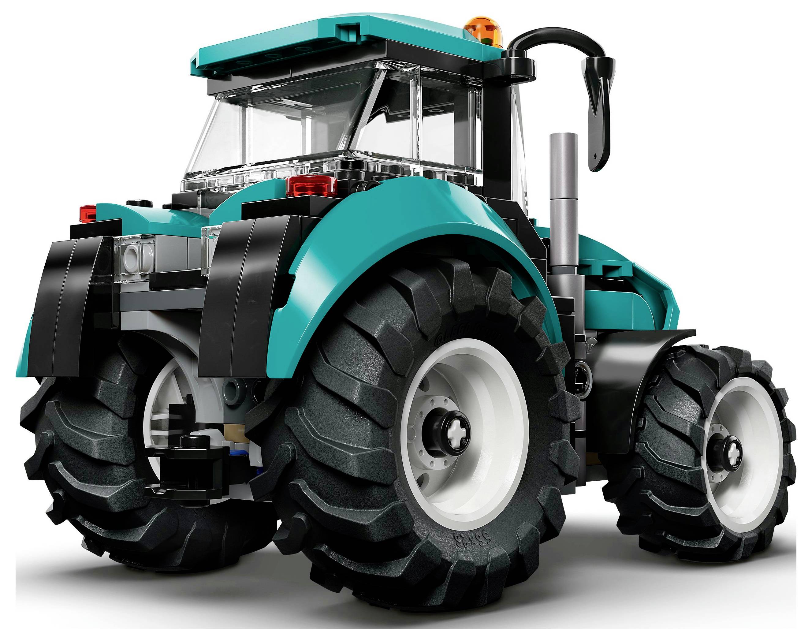 Ein türkis-schwarzes LEGO-Traktormodell mit großen Hinterrädern, sichtbarem Auspuffrohr und einer durchsichtigen Fahrerkabine, von der hinteren linken Seite betrachtet.