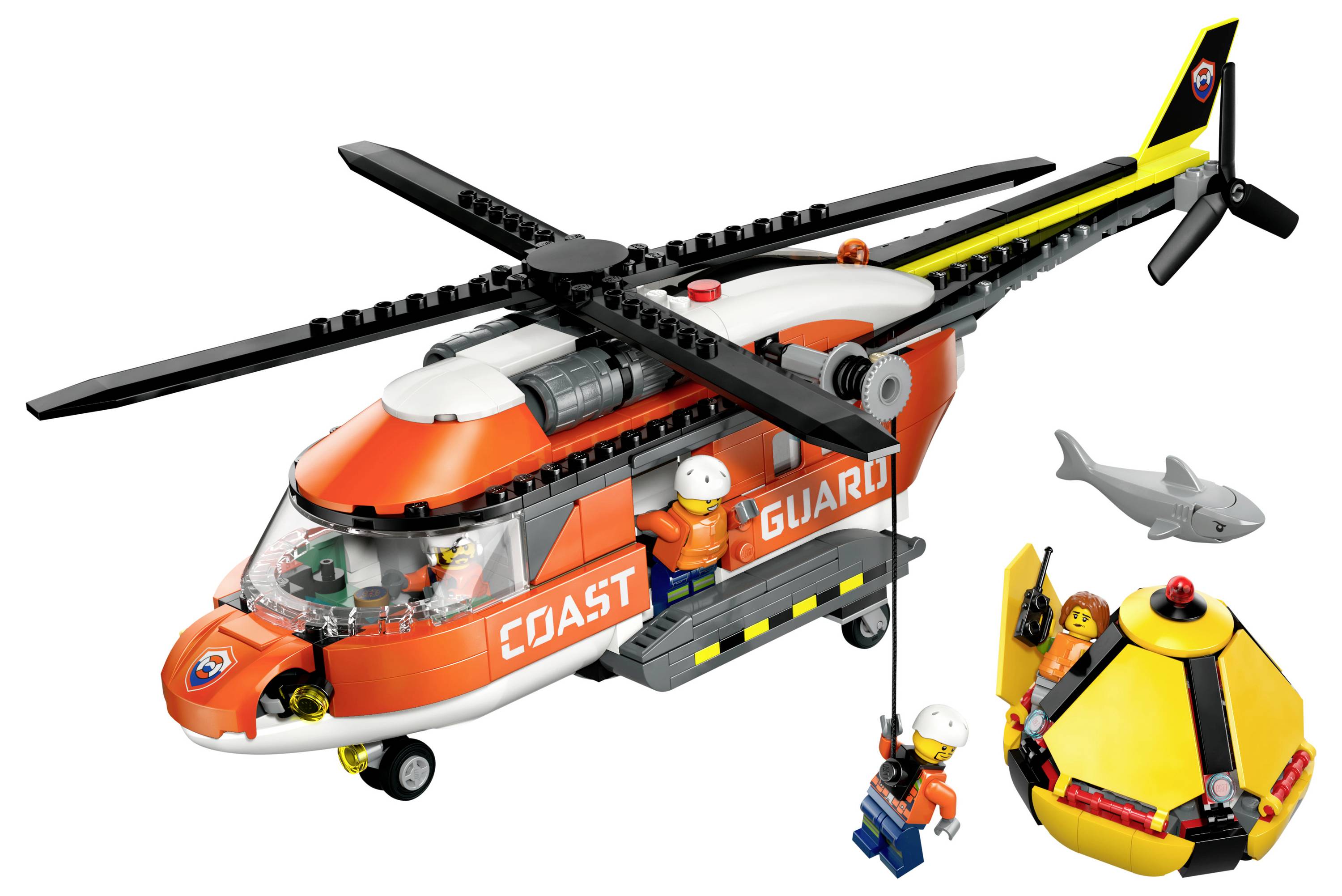 Ein Spielzeughubschrauber mit der Aufschrift "Küstenwache", in dem eine Rettungsteamfigur sich zu einem gelben Schlauchboot hinabsenkt, begleitet von einem Spielzeughai.