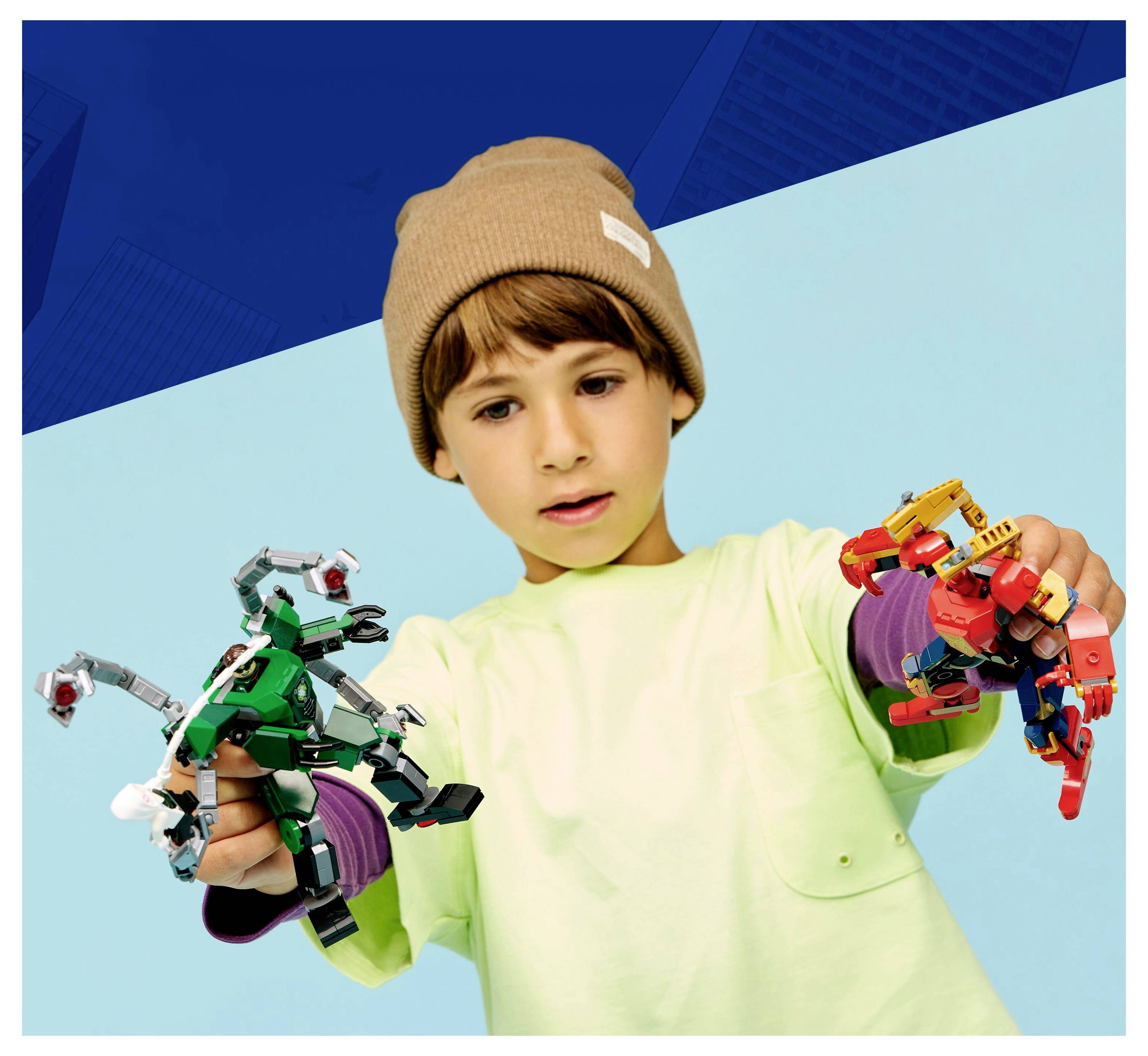 Ein Kind mit einer beigen Mütze spielt mit bunten Roboterspielzeugen und hält jeweils eines in jeder Hand vor einem blauen Hintergrund.