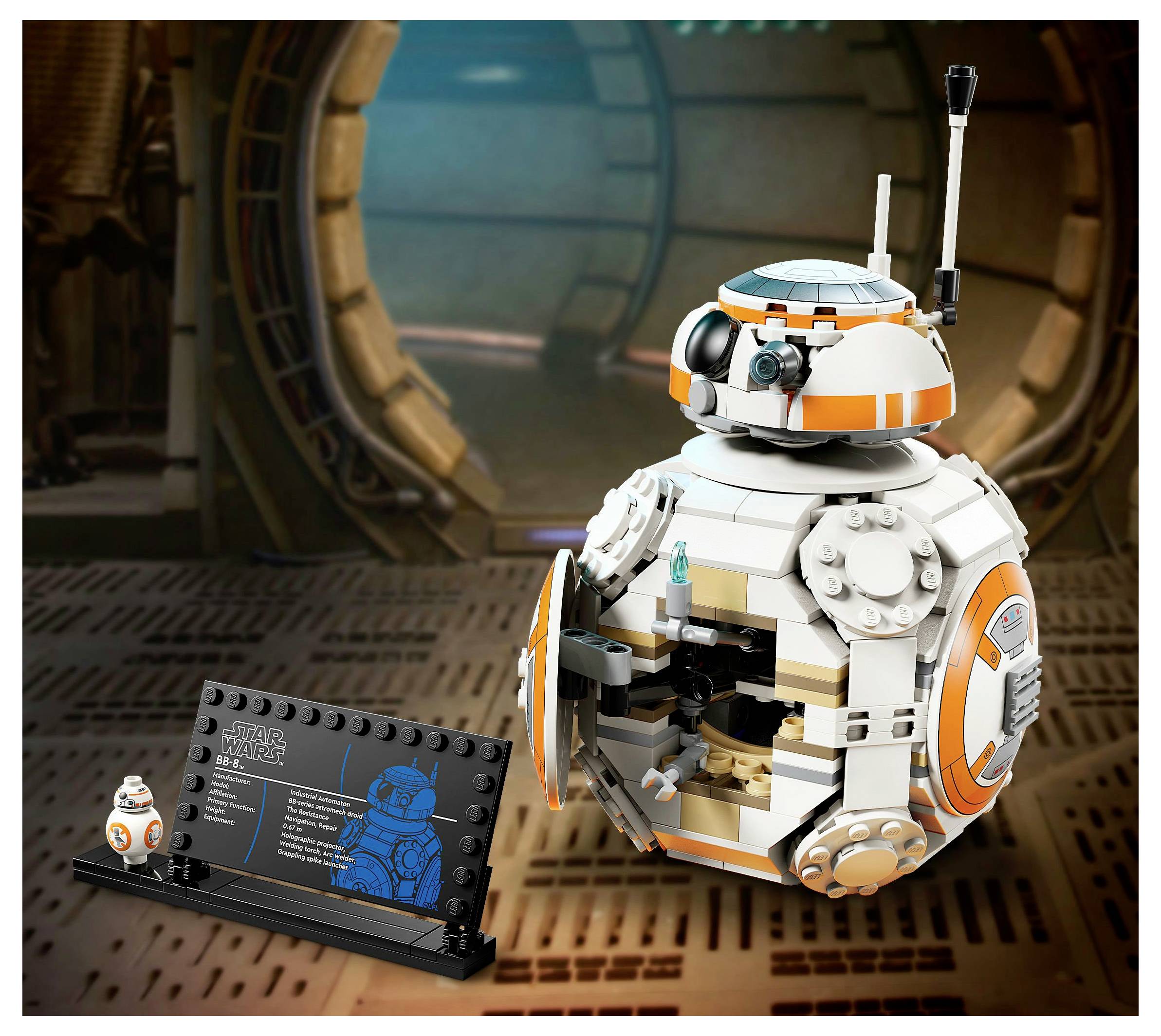 Ein Modell eines kugelförmigen Droiden mit einer kleinen Antenne und orangefarbenen Akzenten ist geöffnet, um die Innenkomponenten zu zeigen, daneben steht ein Ausstellungsschild.