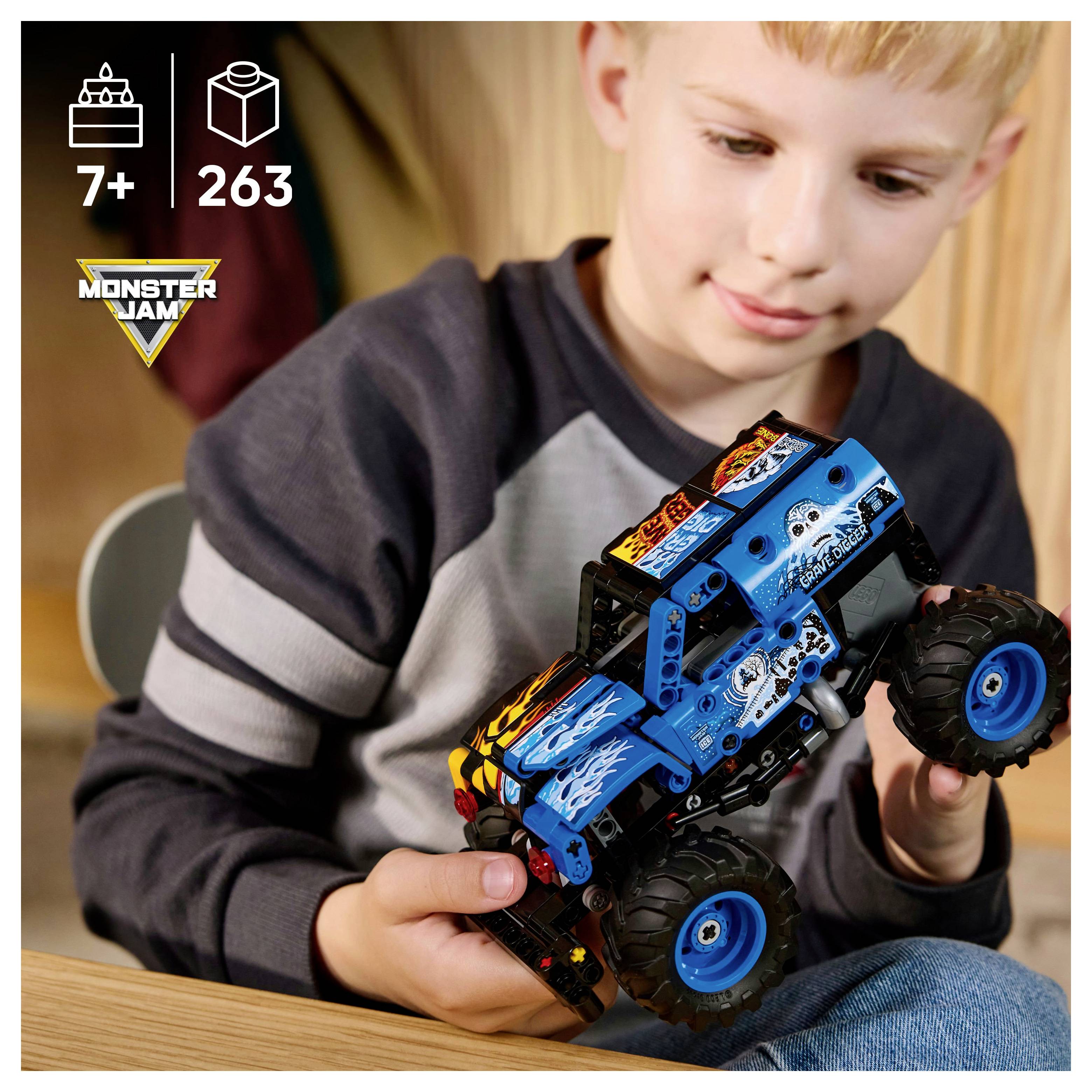 Ein Kind hält einen blauen und schwarzen Spielzeug-Monstertruck, der aus ineinandergreifenden Bausteinen besteht und große Reifen sowie Flammenaufkleber aufweist. Die Verpackung zeigt 263 Teile für Kinder ab 7 Jahren an.