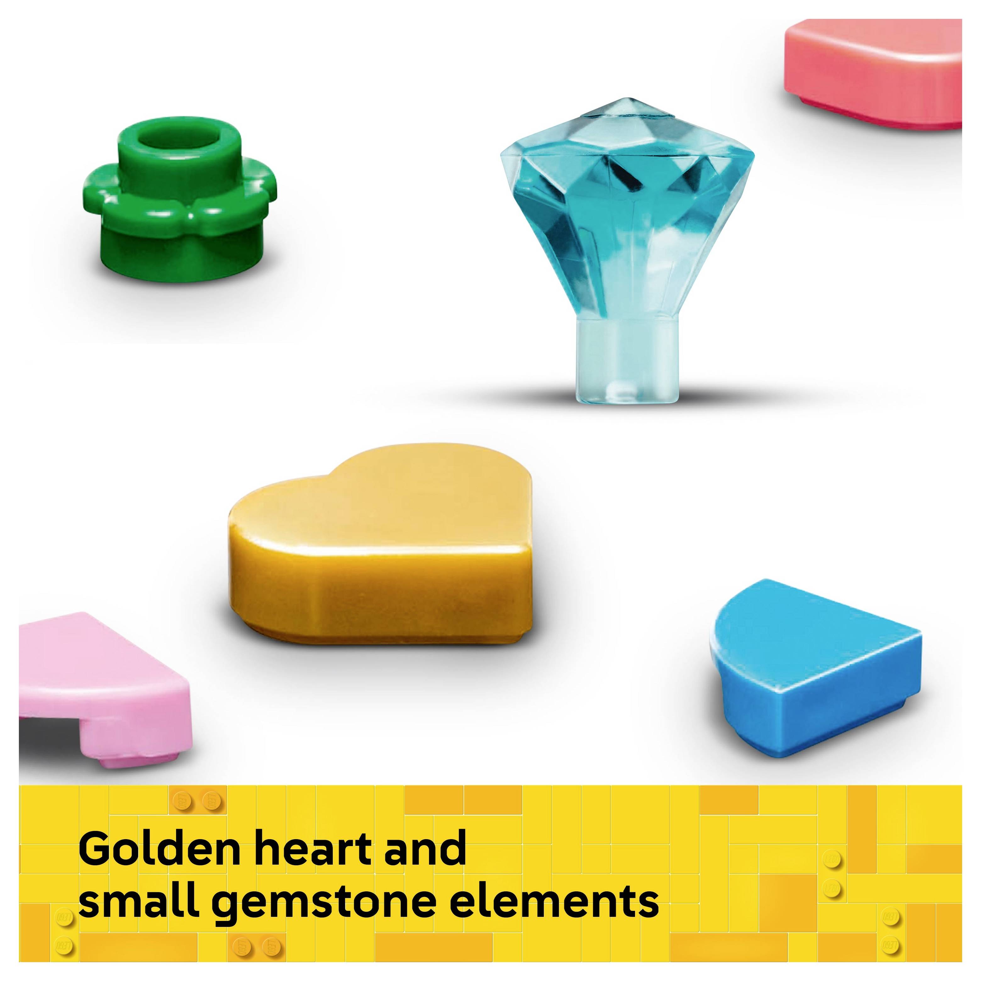 Verschiedene bunte Spielzeugformen, darunter ein goldenes Herz und ein blauer Edelstein, auf einer weißen Oberfläche angeordnet.