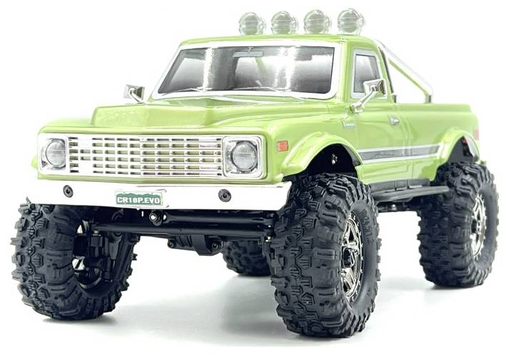 Ein grüner, ferngesteuerter Geländewagen mit großen schwarzen Reifen und vier Scheinwerfern auf dem Dach.