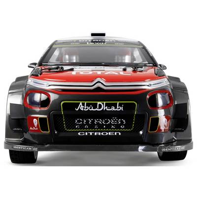 Ein rot-schwarzer Citroën-Rallyewagen mit 'Abu Dhabi' und 'Total' Logos auf der Motorhaube, versehen mit Renndekors und Sponsorenaufklebern.