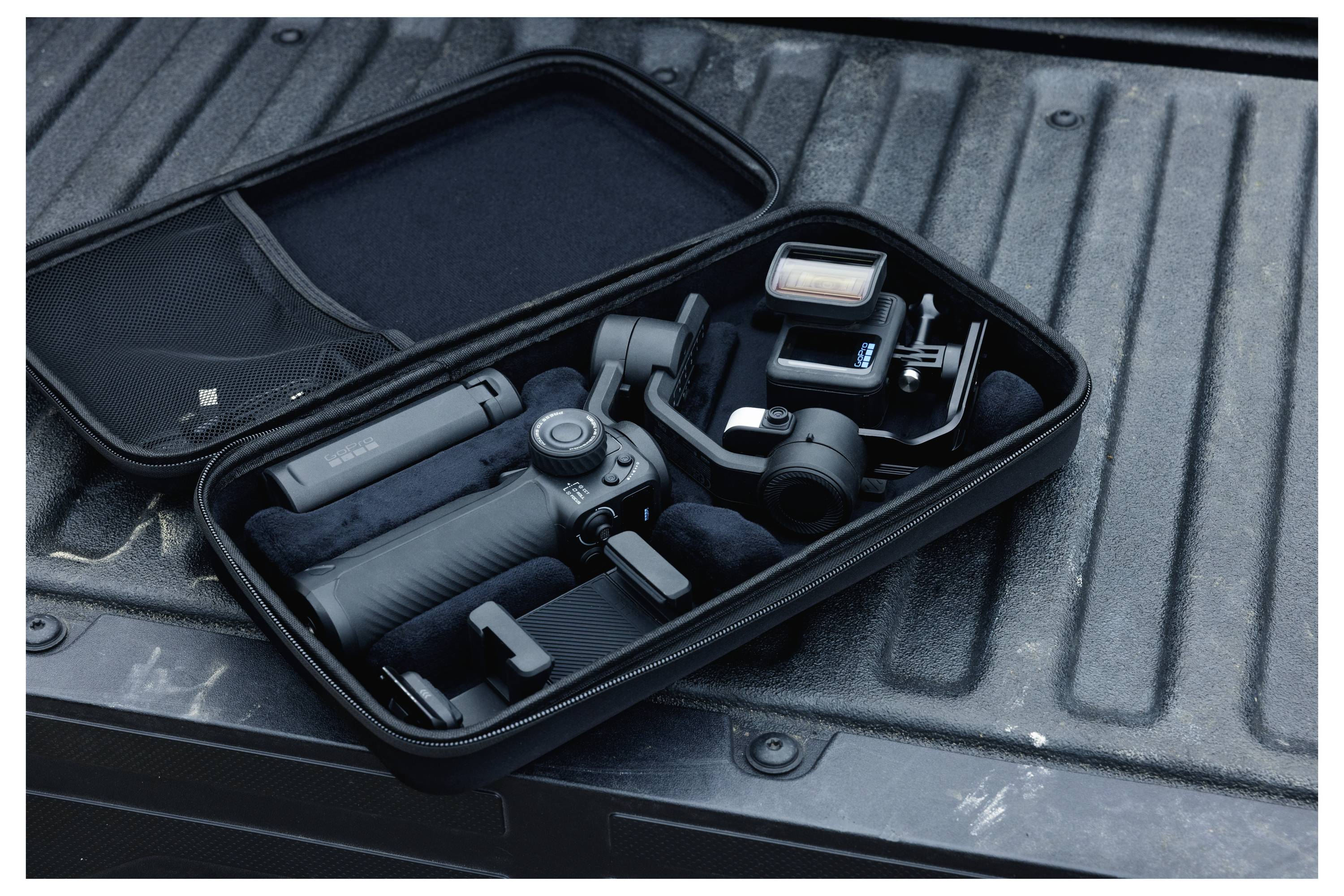 Ein schwarzer Transportkoffer, der auf einer Ladefläche geöffnet ist, zeigt einen Kamera-Gimbal-Stabilisator, der zusammen mit Zubehör übersichtlich angeordnet ist.