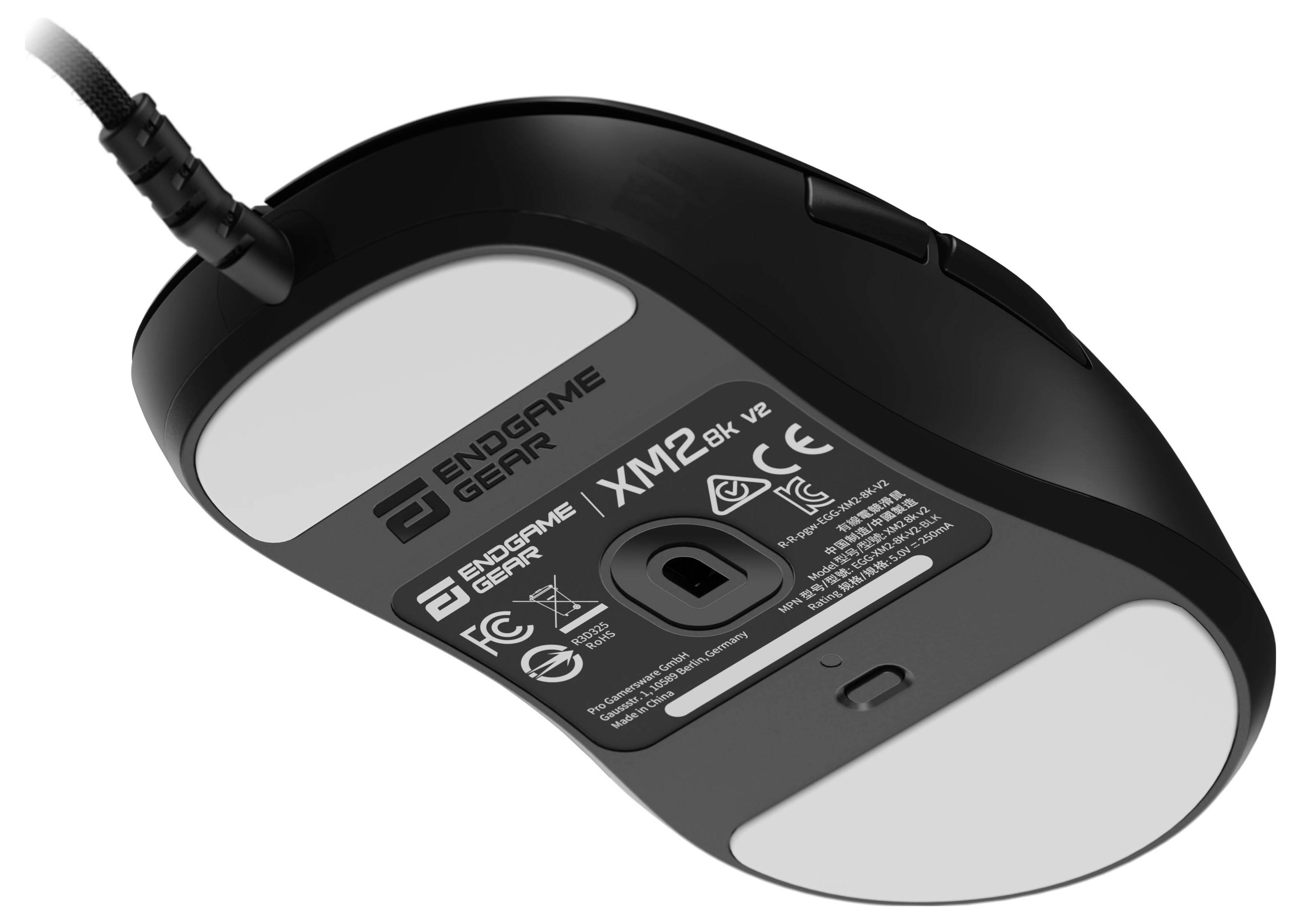 Das Bild zeigt die Unterseite einer schwarzen Endgame Gear Gaming-Maus mit zwei großen weißen Gleitmittelflächen und einem sichtbaren Sensor.