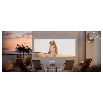 Außenterrasse mit Sonnenuntergang, auf der ein Projektor ein Paar auf einem Feld auf einer großen Leinwand zeigt. Vier Liegestühle sind zur Leinwand ausgerichtet.