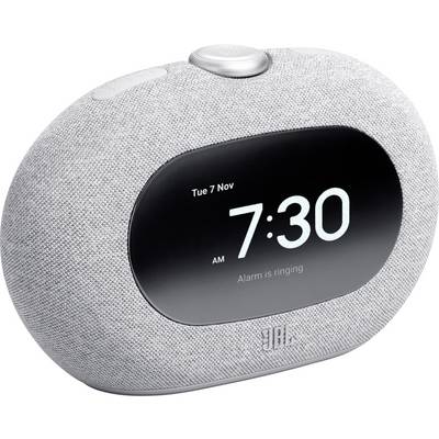 Eine kleine, abgerundete intelligente Weckuhr mit Stoffbezug zeigt '7:30 Uhr' und die Nachricht 'Alarm klingelt' auf ihrem digitalen Display.