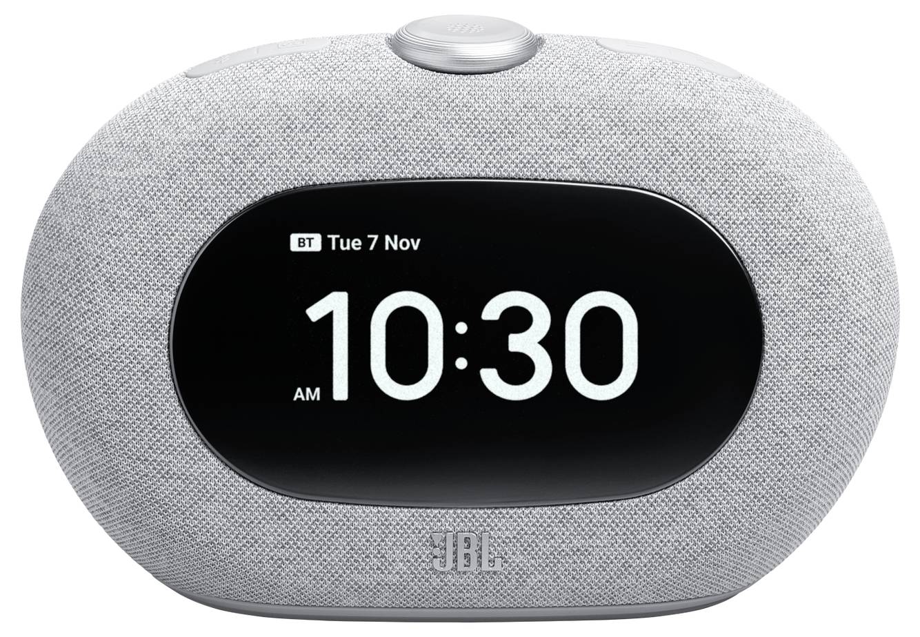 Ein intelligenter Lautsprecher mit einem digitalen Display, auf dem 'BT Dienstag 7. Nov' und '10:30 Uhr' angezeigt werden. Das Gerät ist grau und oval geformt.