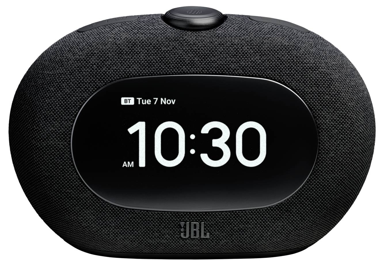 Eine schwarze intelligente Wecker mit Stoffgitter und digitalem Display, auf dem 'BT Di 7 Nov 10:30' angezeigt wird, der die aktuelle Uhrzeit und das Datum zeigt.