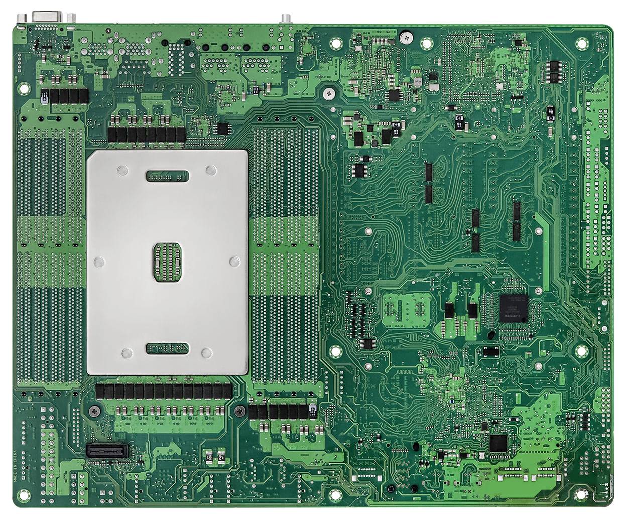 Eine grüne Leiterplatte mit einer zentralen silbernen Fläche, die einen kleinen Chip beherbergt, umgeben von verschiedenen elektronischen Komponenten und Leiterbahnen.