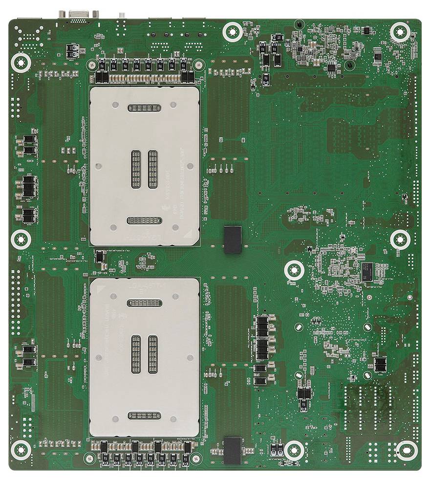 Eine grüne Leiterplatte mit zwei großen rechteckigen Komponenten, zentral platziert, wahrscheinlich CPU-Sockel, und mehreren kleineren Komponenten.