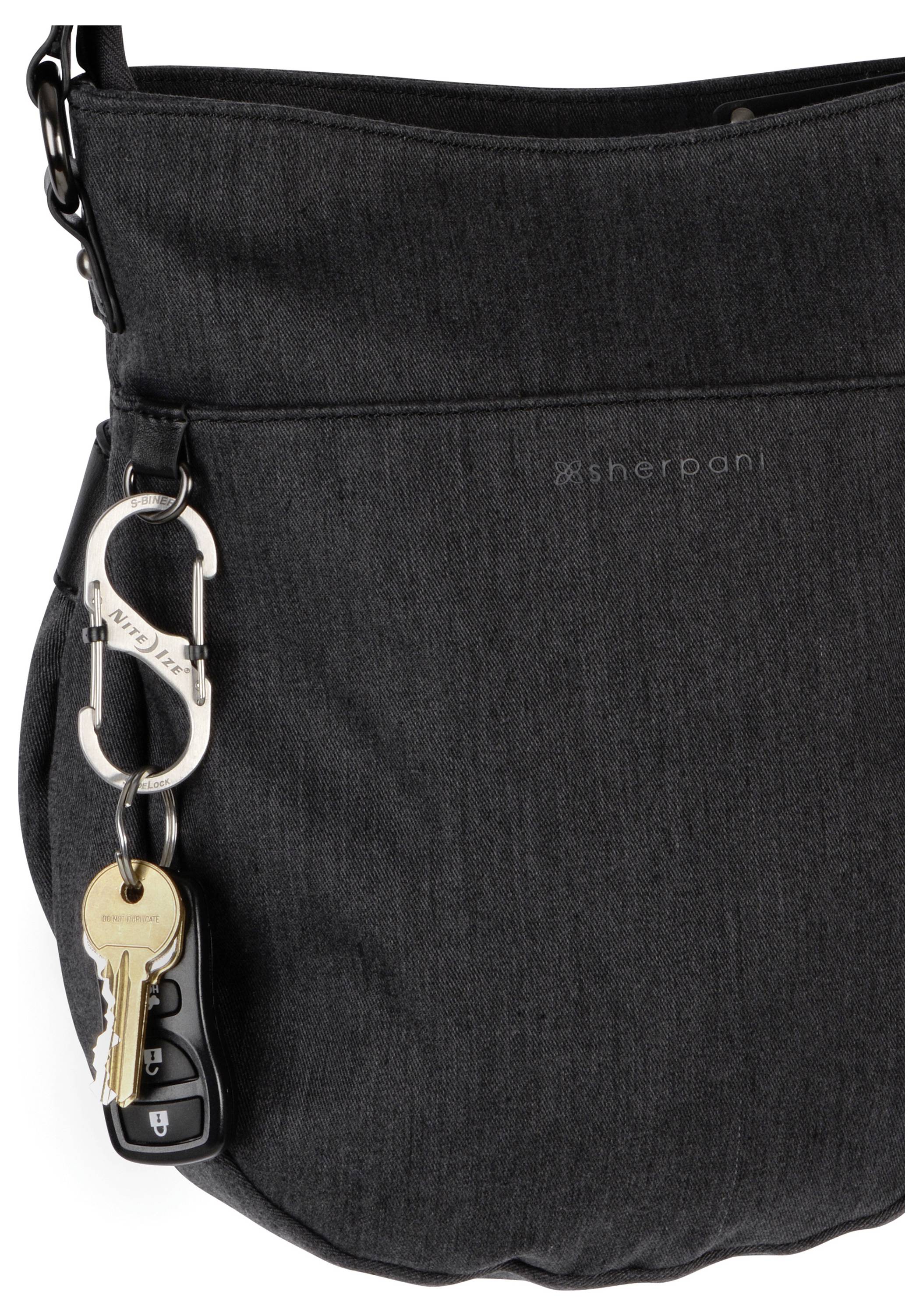 Eine schwarze Sherpani-Tasche mit einem Karabinerhaken, an dem zwei Schlüssel und eine Autofernbedienung befestigt sind.