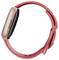 Eine Smartwatch in Roségold mit einem rosa Silikonband, von der Seite betrachtet, wobei der Displayrand und ein Teil des Armbands zu sehen sind.