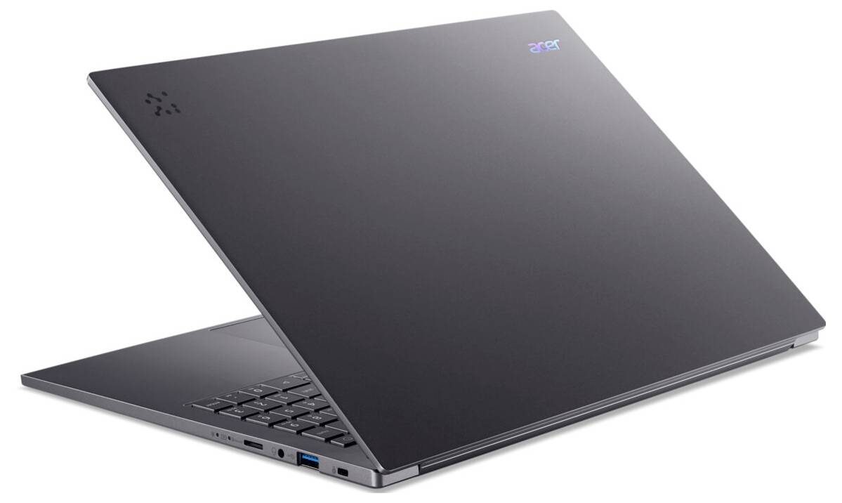 Ein schlanker, schwarzer Laptop, halb geöffnet, mit sichtbarer Tastatur und Anschlüssen an der Seite. Der Laptop steht vor einem schlichten weißen Hintergrund.
