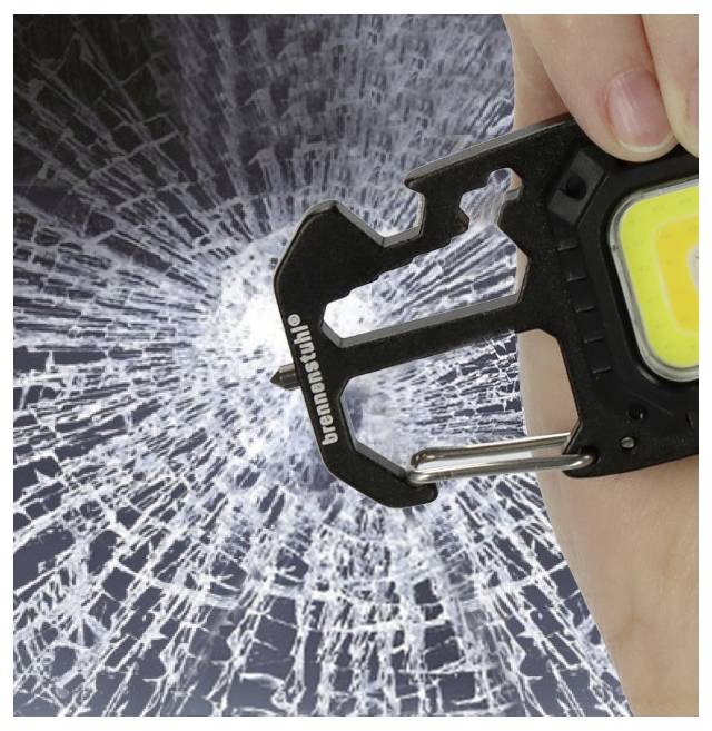 Eine Hand hält einen schwarzen Multitool vor einer spinnwebförmigen, gerissenen Oberfläche und deutet damit an, dass das Werkzeug zum Zerschlagen von Glas verwendet werden kann.